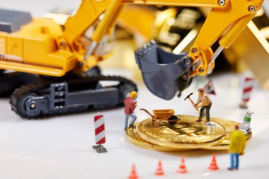 Küçük bir madenci altın sikke ile grafik kartı eşeliyor. Bitcoin madenciliği ve kripto para birimi kavramı. 