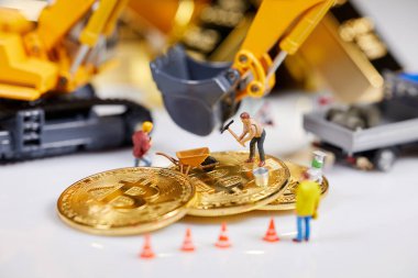 Küçük bir madenci altın sikke ile grafik kartı eşeliyor. Bitcoin madenciliği ve kripto para birimi kavramı. 