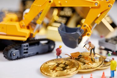 Küçük bir madenci altın sikke ile grafik kartı eşeliyor. Bitcoin madenciliği ve kripto para birimi kavramı. 