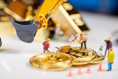 Küçük bir madenci altın sikke ile grafik kartı eşeliyor. Bitcoin madenciliği ve kripto para birimi kavramı. 