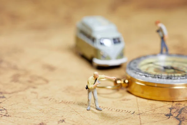 Travelling concepts. Group of traveler miniature mini figures with camera standing and walking on old world map