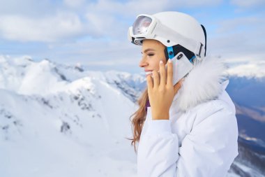 Yüksek dağlarda bir kadın cep telefonuyla boş boş konuşuyor.      