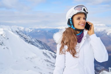 Yüksek dağlarda bir kadın cep telefonuyla boş boş konuşuyor.      