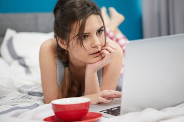  Güzel genç kadın sabah yatakta kahve içme.