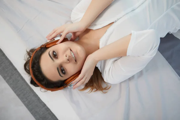 Yatakta Kız Kulaklıklar Müzik Dinler — Stok fotoğraf