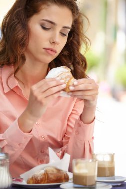 İtalya açık havada kafede oturmuş, kahve içme ve kruvasan yemek güzel sarışın kadın portresi.