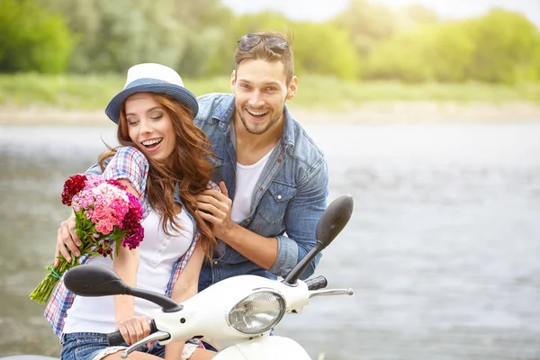 Een Man Geeft Bloemen Mooie Vrouw Achtergrond Rivier Scooter — Stockfoto