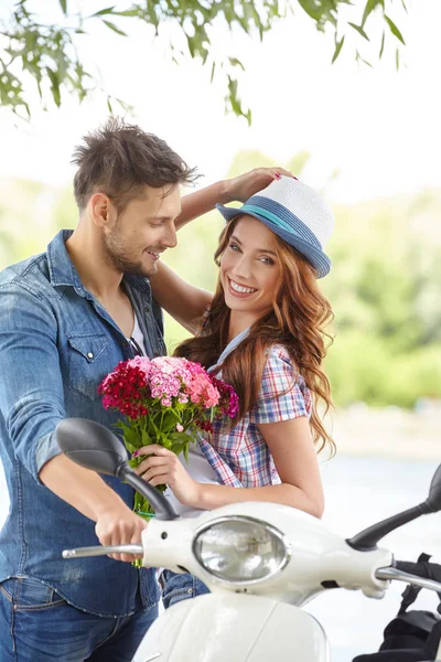 Een Man Geeft Bloemen Mooie Vrouw Achtergrond Rivier Scooter — Stockfoto