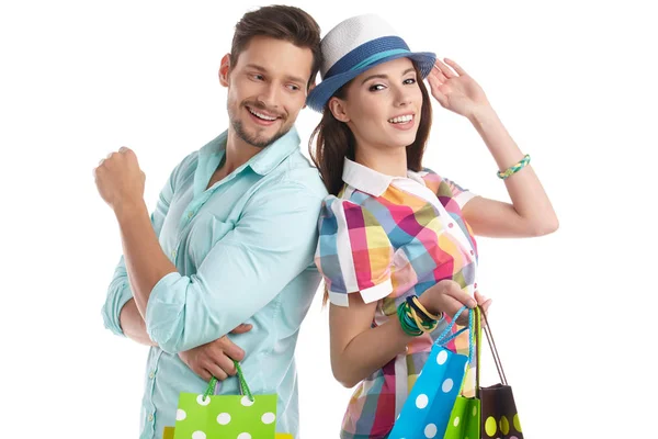 白い背景の上のショッピング バッグと魅力的な若いカップル — ストック写真
