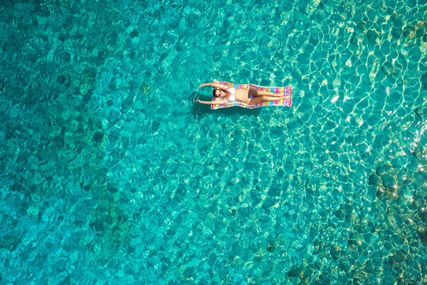 Denizde bir yatak üzerinde bikini güzel bir genç kadının havadan görünümü 