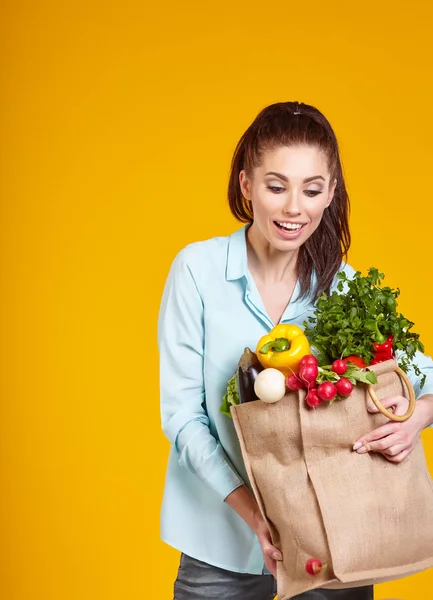 healthy lifestyle with green vegan food. young woman hold shopping bag with vegetables.