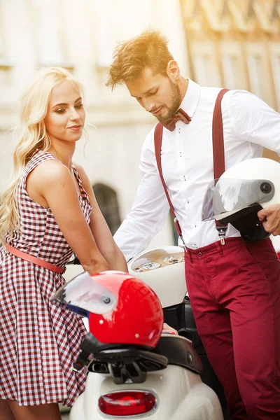 Влюбленная пара на улице с ретро-скутером — стоковое фото