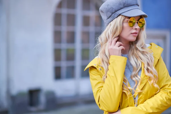 Ragazza bionda con un impermeabile giallo — Foto Stock