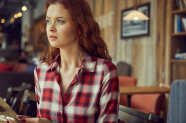 Kırmızı saçlı kadın Cafe kitap okumak. Şehir sonu kavramı