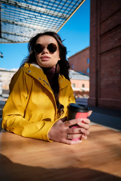 La chica está tomando café en un café en la calle. — Foto de Stock