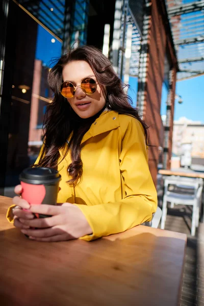 La chica está tomando café en un café en la calle. — Foto de Stock