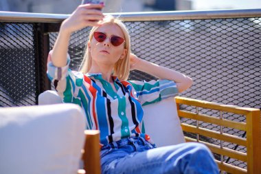 kız bir buildin çatısında kendini bir resim çekiyor