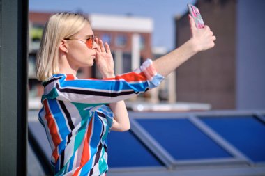 kız bir buildin çatısında kendini bir resim çekiyor