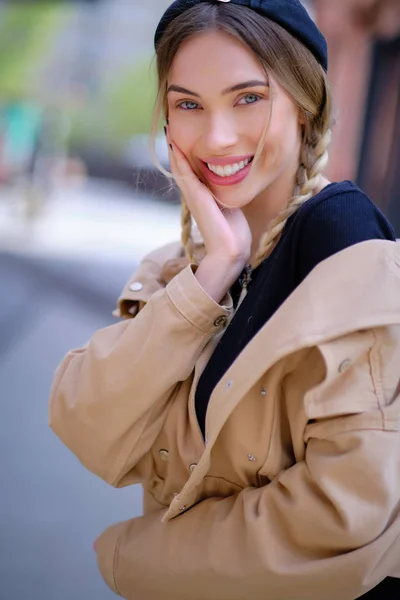 Geweldige mooie jonge vrouw in een beige jasje met een baret POS — Stockfoto