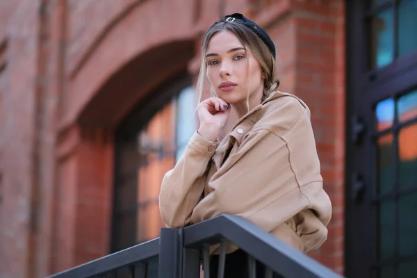 놀라운 아름다운 젊은 여자 에 a 베이지 색 재킷 와 a 베레모 pos — 스톡 사진