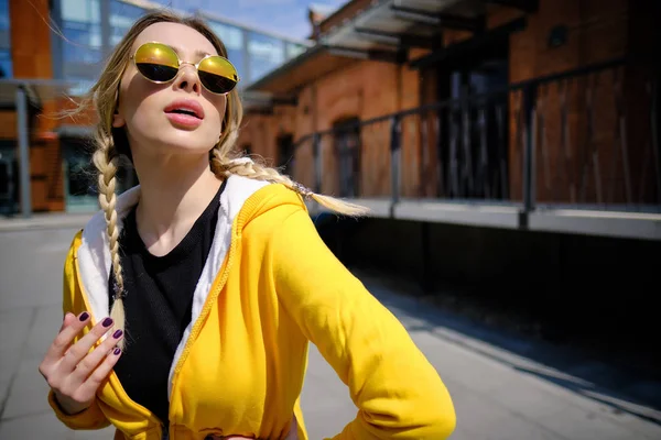 Όμορφη γυναίκα με ένα κίτρινο πουλόβερ και γυαλιά ηλίου στο St — Φωτογραφία Αρχείου