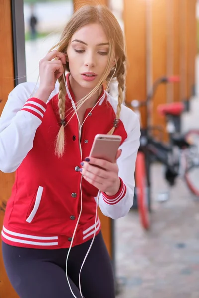 Una chica en bicicleta descansando escuchando música en los auriculares — Foto de Stock
