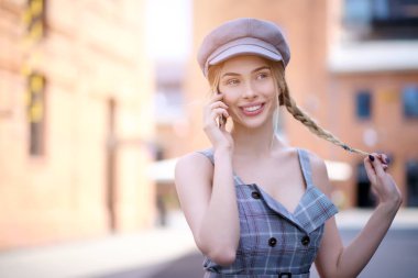 Genç bir kadın cep telefonuyla konuşuyor. 