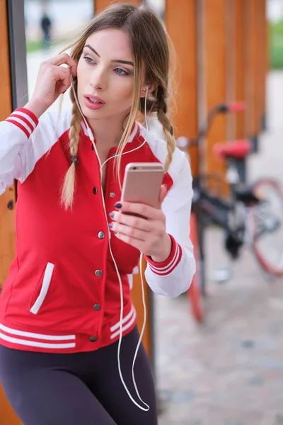 Deporte bonita mujer escucha música en los auriculares cerca de retro pi — Foto de Stock