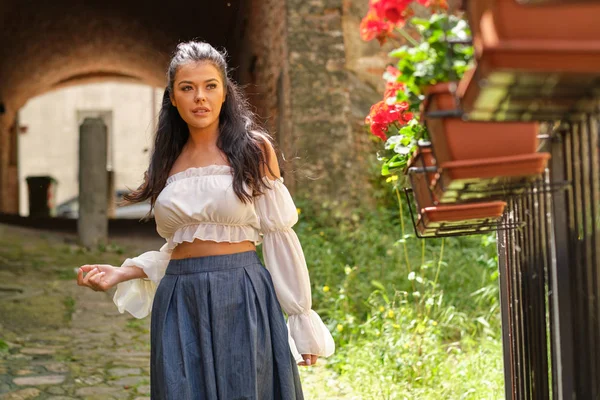 Uma mulher fica na frente de seu jardim em casa italiano — Fotografia de Stock