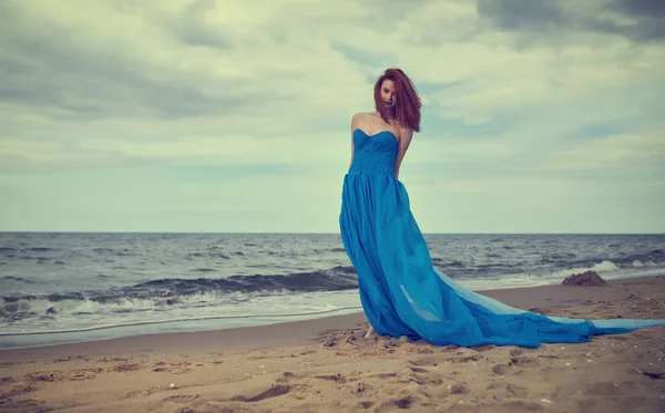 Woman in a blue dress on the beach. Summer woman in a blue dress — Stock Photo, Image