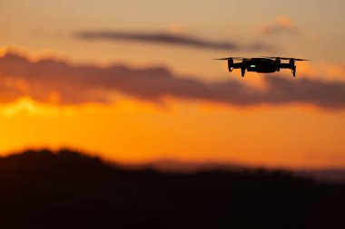 Güneş batımına karşı Drone Uçan silueti. Uçan silueti 