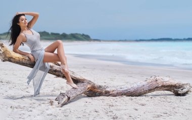 Sahilde içinde zarif güzel genç kadın 