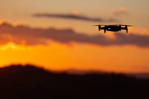Silueta voladora de dron contra atardecer. Silueta voladora de — Foto de Stock