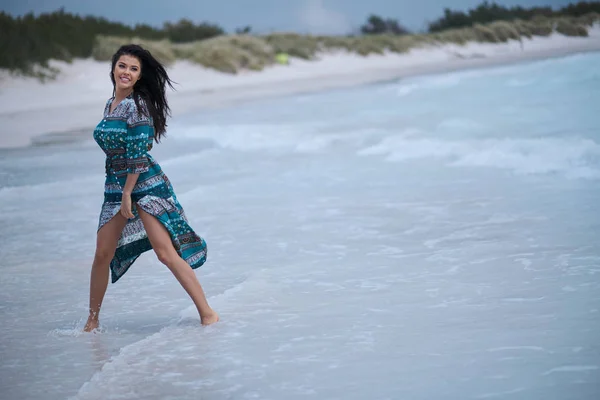 Vacker ung kvinna i elegant klänning på stranden — Stockfoto