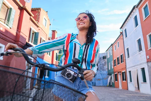 Kvinna med vintage kamera ridning retro cykel på en färgglad ita — Stockfoto