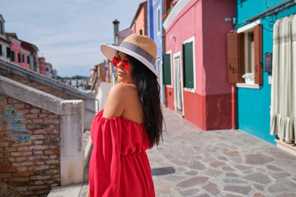 Женщина-путешественница позирует среди красочных домов на острове Бурано, Венеция. Концепция туризма в Италии
 