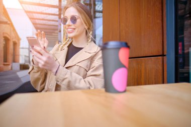 Kafeteryada akıllı telefon kullanan bir kadın. akıllı telefon veya cep telefonu 