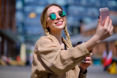 Kadın akıllı telefondan selfie çekiyor. 