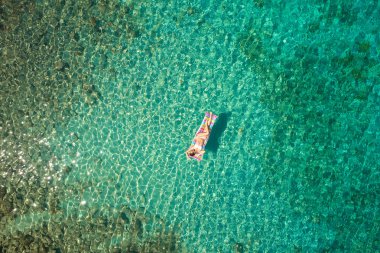 Floa olan beyaz bikini güzel bir kadının yukarıdan aşağıya görünümü