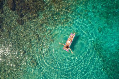 Floa olan beyaz bikini güzel bir kadının yukarıdan aşağıya görünümü