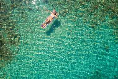 Floa olan beyaz bikini güzel bir kadının yukarıdan aşağıya görünümü
