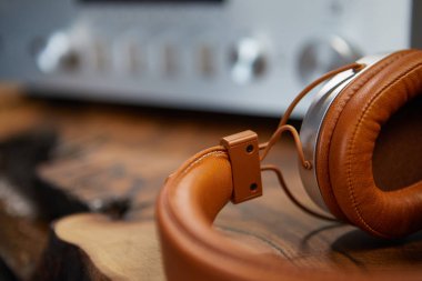 Vintage Kulaklıklar ahşap bir masanın üzerinde yatıyor. Arka plan amplifikatörü h