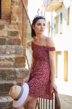 Küçük bir İtalyan kasabasının sokaklarında şık giyinmiş bir kadın.