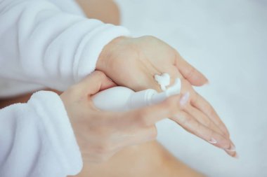 El kremi uygulayan güzel genç kadının kırpılmış görüntüsü