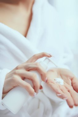 El kremi uygulayan güzel genç kadının kırpılmış görüntüsü