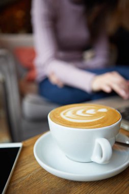 Masada iki fincan kahve ve kek, latte sanatı