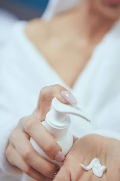 Cropped image of beautiful young woman applying hand cream while — Stock Photo, Image