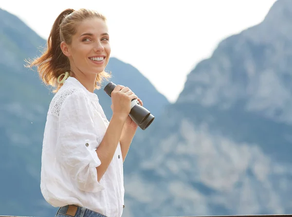 Donna turistica in cima alla montagna guardando attraverso il binocolo — Foto Stock