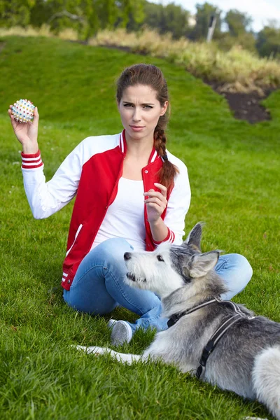 Mulher brincando com seu cão ao ar livre — Fotografia de Stock