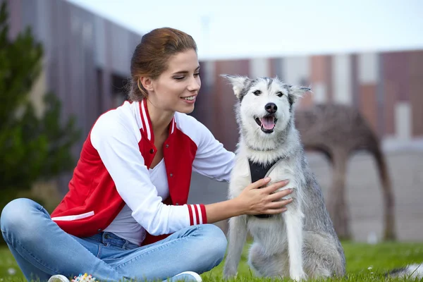 女性は彼女の犬は屋外で遊ぶ — ストック写真